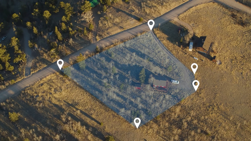 A marked GPS boundary surrounds a rural property, showing precise location tracking in a wooded area